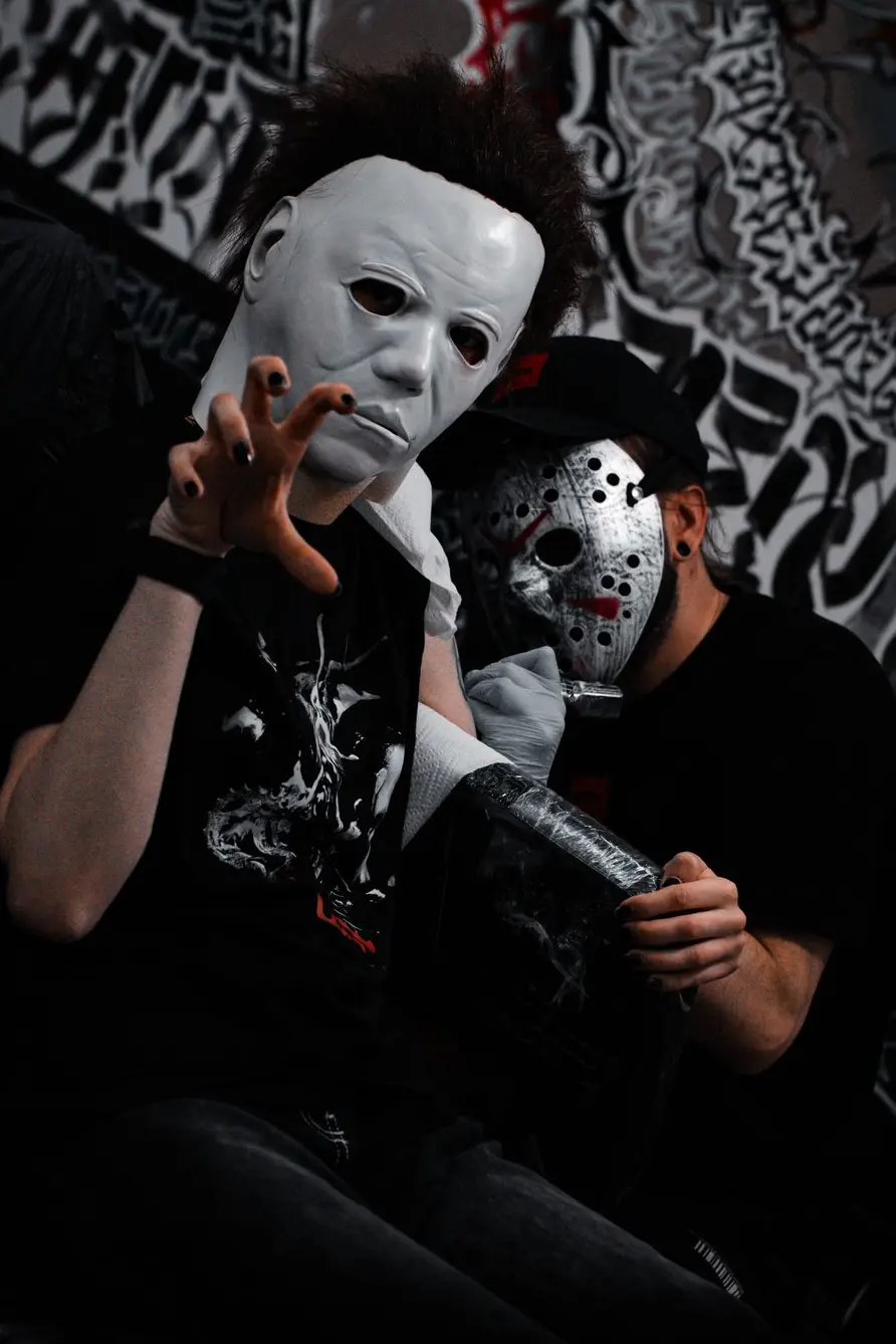 tatuażysta i klient w maskach z filmów horror